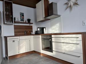 a kitchen with white cabinets and a stove at Appartements Gabat Nähe Red Bull Ring in Sankt Michael in Obersteiermark