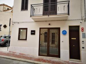 een wit gebouw met een deur en een balkon bij CIELO D' ALCAMO in Alcamo