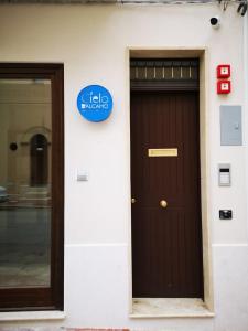 une porte menant à un bâtiment avec un panneau bleu dans l'établissement CIELO D' ALCAMO, à Alcamo