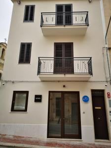 - un bâtiment blanc avec un balcon et une porte dans l'établissement CIELO D' ALCAMO, à Alcamo