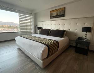 a bedroom with a large bed and a large window at Hotel Airport Travel in Bogotá