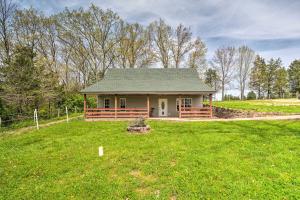 een klein huis in het midden van een veld bij Private and Quiet Boone Terre Home with Fire Pit! in Bonne Terre