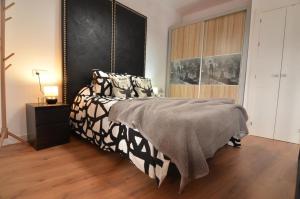 1 dormitorio con 1 cama con manta blanca y negra en Luna´s home. Precioso loft en Bollullos par del Condado en Bollullos par del Condado