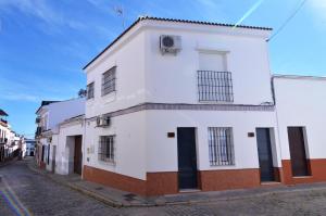 un edificio bianco con finestre nere su una strada di Luna´s home. Precioso loft en Bollullos par del Condado a Bollullos par del Condado