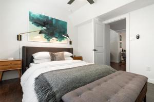 Abode Houston - Montrose Downtown في هيوستن: غرفة نوم بسرير ودهان على الحائط