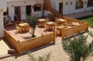 a restaurant with tables and chairs in a courtyard at Jowhara Hotel in Dahab