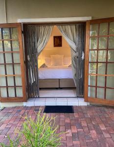 a porch with a bed in a room with sliding glass doors at Waterloo Guest House in Durban