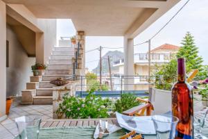 a patio with a table with a bottle of wine at Monemvasia Modern flat with Partial View in Monemvasia