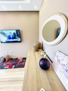 a living room with a table and a tv on the wall at Apartman Centar sa sigurnim parkingom in Sarajevo