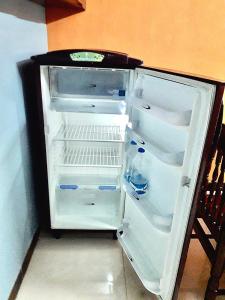 un réfrigérateur vide avec une porte ouverte dans une pièce dans l'établissement Chan Maison @ Lakshmi Gardens, à Pondichéry