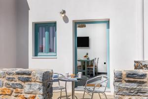 a room with a table and chairs and a tv at Ligaridia Apartments in Moutsoúna