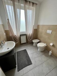 baño con lavabo y aseo y ventana en B&B FR House Affittacamere Colleferro, en Colleferro