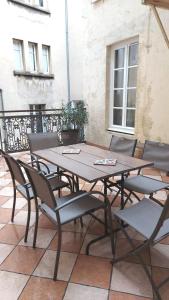 een houten tafel en stoelen op een patio bij Résidence Aristide Briand - Appartements en Centre Ville in Vichy