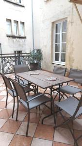 une table et des chaises en bois sur une terrasse dans l'établissement Résidence Aristide Briand - Appartements en Centre Ville, à Vichy