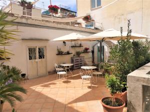 un patio extérieur avec tables, chaises et parasols dans l'établissement Palazzo della Loggia B&B, à Naples