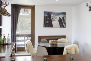 ein Esszimmer mit einem Tisch, Stühlen und einem Fenster in der Unterkunft HelloChalet - Ski paradise Apartment - Ski- to door with big terrace overlooking skiruns in Breuil-Cervinia