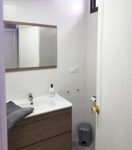 Baño blanco con lavabo y espejo en Happy Arimar Apartments Puerto Rico, en Mogán