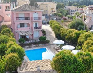 a villa with a swimming pool in a town at CHA Nanakas Village Inn in Corfu