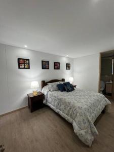 a bedroom with a bed and a table with a lamp at HERMOSO APARTAMENTO EN SABANETA Cerca al Centro Comercial Mayorca in Sabaneta