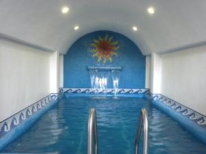 a swimming pool in a room with a blue wall at Hotel Victoria in Zihuatanejo