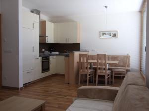 a kitchen and living room with a table and chairs at Tauberhof Apartments in Bressanone