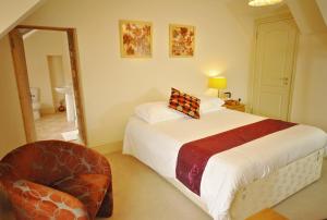 1 dormitorio con 1 cama grande y 1 silla en The Castle Hotel, en Talgarth