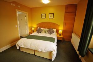 a bedroom with a large bed and two lamps at The Castle Hotel in Talgarth