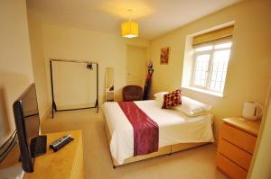 um quarto com uma cama e uma televisão em The Castle Hotel em Talgarth