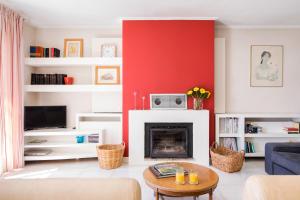 a living room with a red wall and a fireplace at Corfu town tranquility gem in Corfu