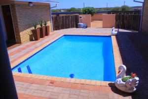 a swimming pool with a swan in a yard at Living Quarters BNB in Bobonong +3 photos