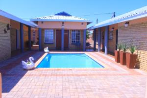 a swimming pool in front of a house at Living Quarters BNB in Bobonong