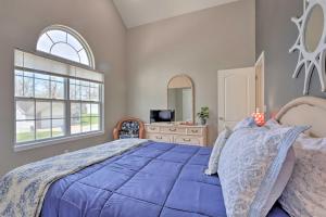 a bedroom with a large blue bed and a window at Less Than 1 Mi to Marina Family-Friendly Osage Beach Home in Osage Beach