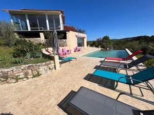 a villa with a swimming pool and a house at DOMAINE MAXXIM in Clermont-lʼHérault