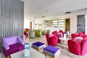 a waiting room with pink chairs and purple chairs at Barceló Teguise Beach - Adults Only in Costa Teguise