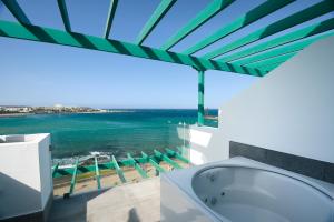 a bathroom with a white tub and a white toilet at Barceló Teguise Beach - Adults Only in Costa Teguise