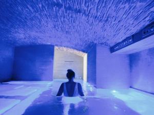 a woman sitting in a swimming pool in a room at Barceló Teguise Beach - Adults Only in Costa Teguise