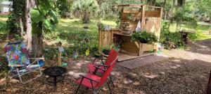 a backyard with two chairs and a grill and a shed at Sleep Birds glamping trailer 5min to the beach in Nokomis