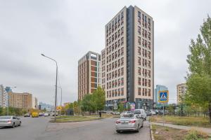 une rue de la ville avec des voitures garées devant de grands bâtiments dans l'établissement ЖК Sauran Towers comfort, à Astana