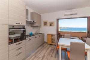 a kitchen with a table and a view of the ocean at Flat Orizzonte Rosso in Palau