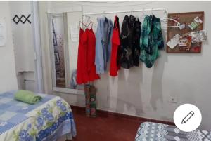 a bedroom with clothes hanging on a wall at Casa amora olinda in Olinda