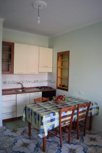 a kitchen with a table with chairs and a sink at Mare e Terme a Guardia Piemontese in Guardia Piemontese Terme