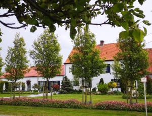 una casa con árboles delante de ella en Vacation Home Mechelhof, en Leffinge