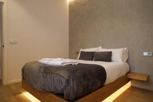 1 dormitorio con 1 cama grande con sábanas y almohadas blancas en MEDINA HOMES PUENTE ROMANO, en Córdoba