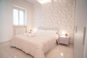 - une chambre avec un lit et un papier peint floral rose dans l'établissement Le Camelie -appartamenti nuovi, à Porto SantʼElpidio
