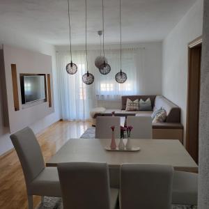 a living room with a table and a couch at Apartman Pati in Livno
