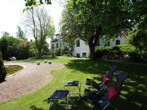 a yard with chairs and a pond and a house at Lägenhet Thujan, Solrosen i Simrishamn-Österlen in Simrishamn