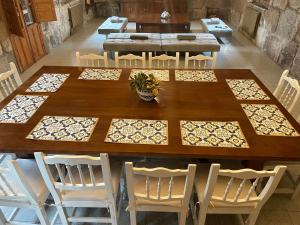 een grote houten tafel met witte stoelen eromheen bij VILLA en PLAYA LIMENS in Cangas de Morrazo