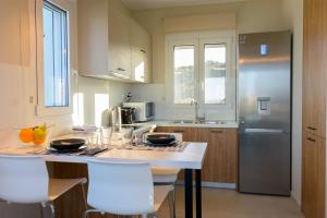 a kitchen with a counter with chairs and a refrigerator at Angelique Luxury apartment in Agios Nikolaos +27 photos