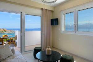 a living room with a couch and a table at Angelique Luxury apartment in Agios Nikolaos