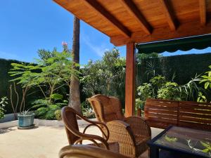 een veranda met rieten stoelen, een tafel en een bank bij Las Tartanas Two Bedroom Bungalow in Playa del Inglés